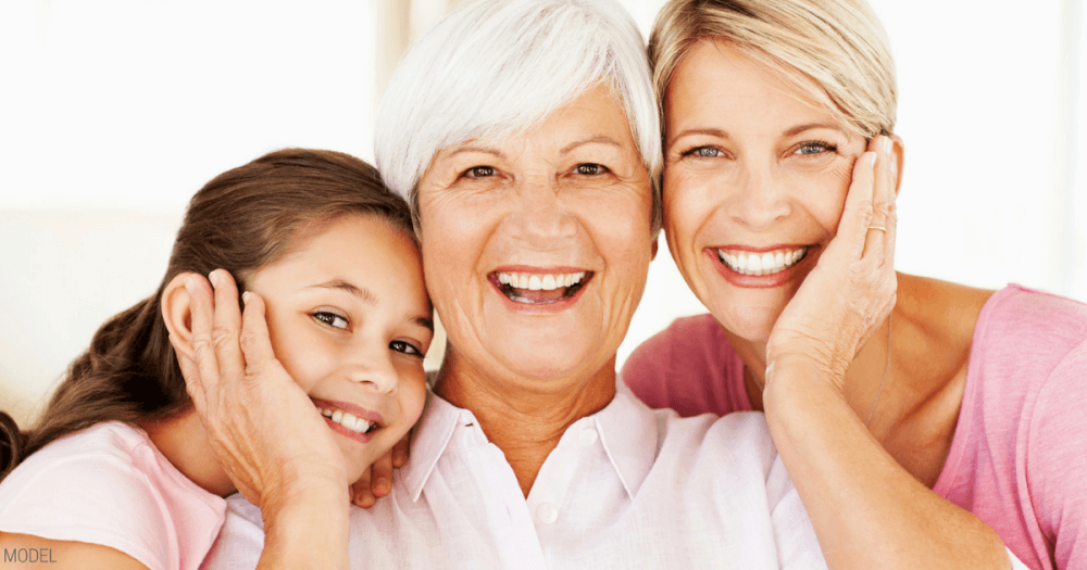 A portrait of three generations of women. Grandaughter, mother and grandmother, with heads together and big smiles