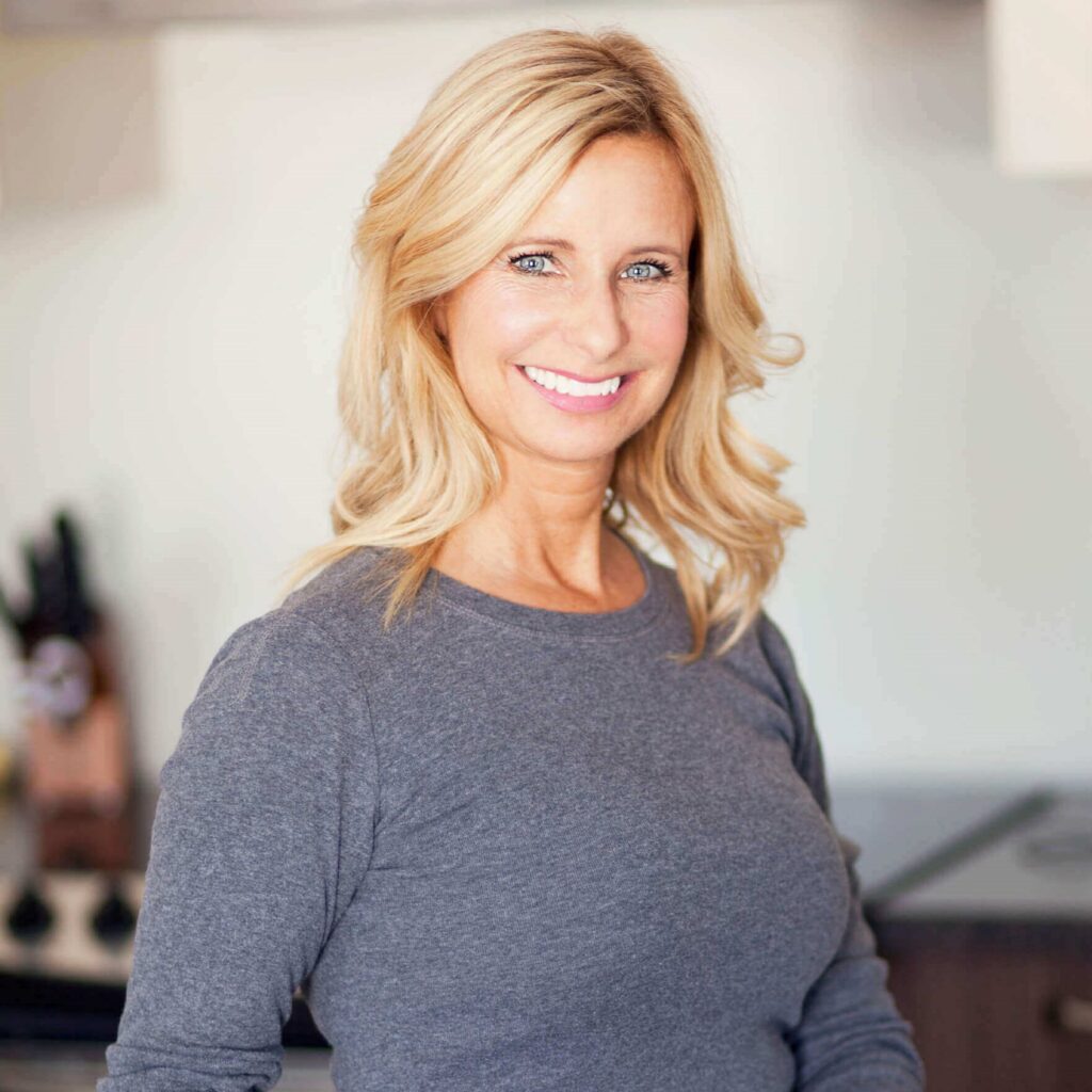 Middle-aged woman with perfect figure, blonde hair and bright blue eyes, smiling confidently