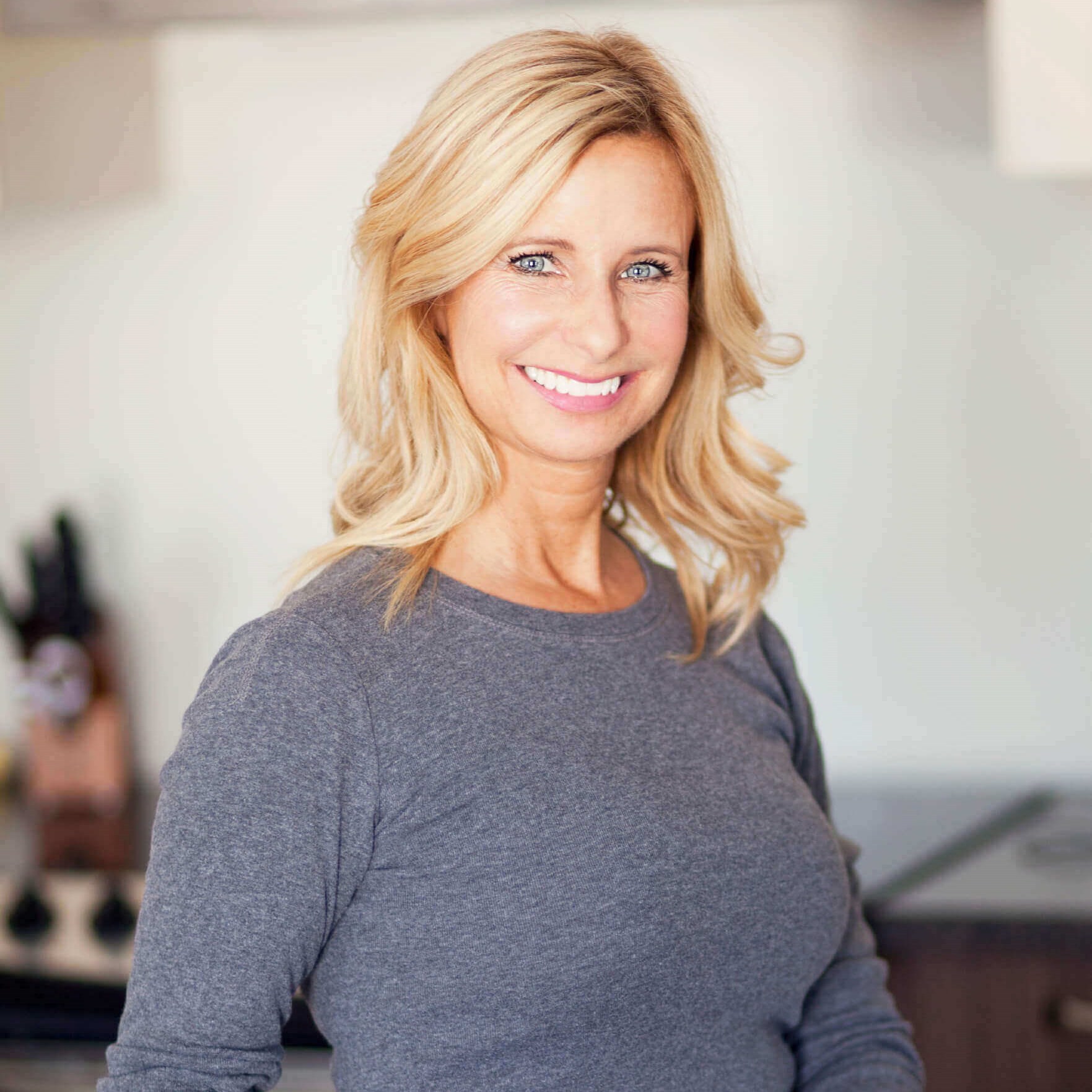 Middle-aged woman with perfect figure, blonde hair and bright blue eyes, smiling confidently