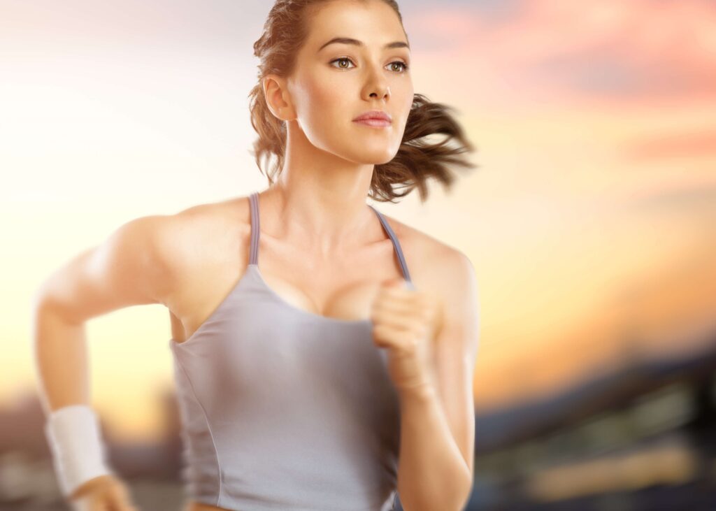 Young, toned, woman, running fast, her bod and the background blurred from the speed