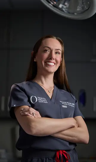 Dr. Amanda Walsh standing with her arms crossed confidently, smiling