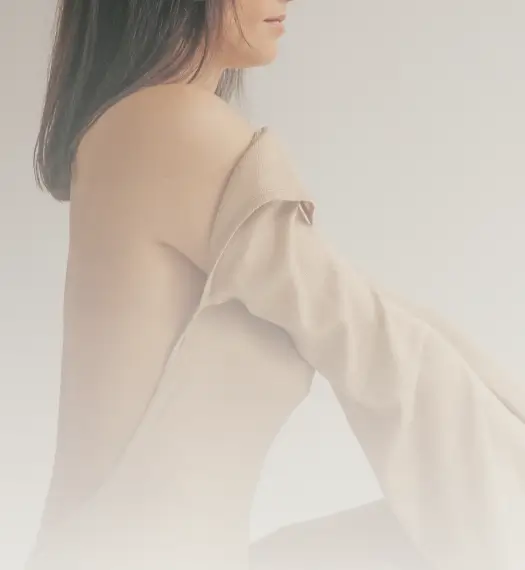 woman's torso covered with loose clothing on the front, graceful line of her back exposed