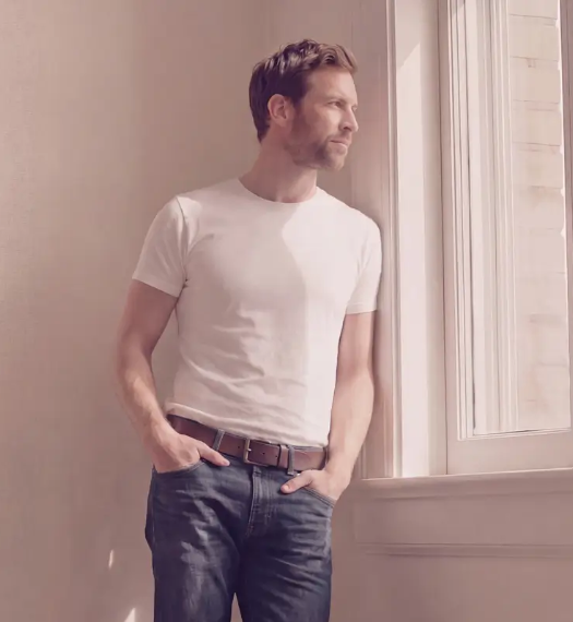 woman sits relaxed in a chair, slumped down with her legs stretched out in front of her